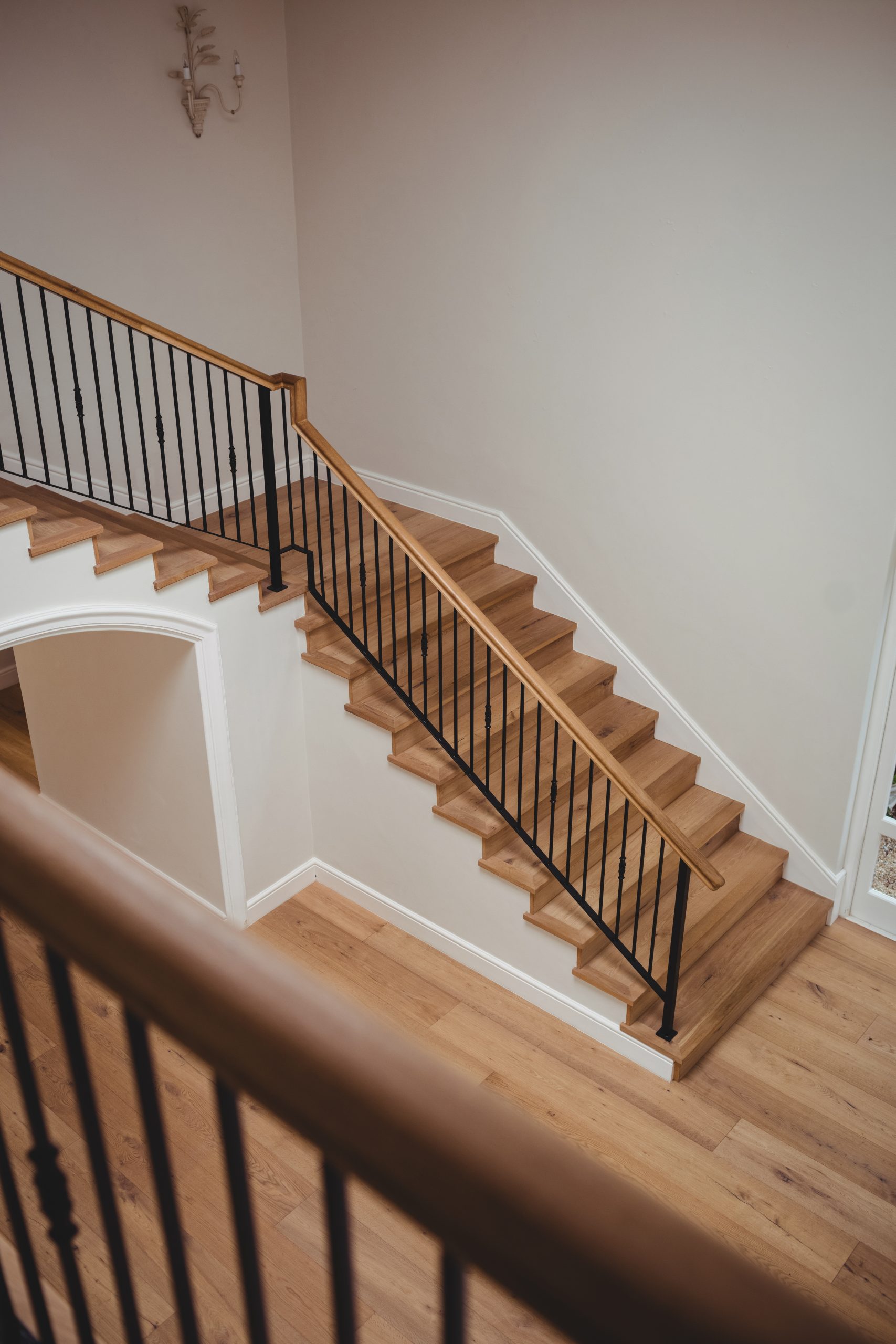 Interior of home with wooden floor and staircase with white walls
