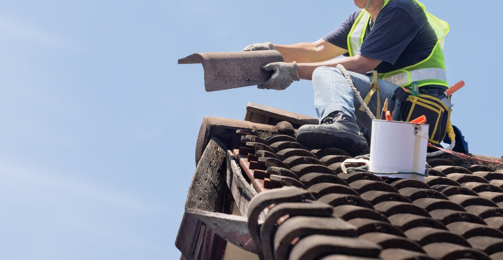 Worker,Man,Repairing,Eaves,And,Tile,Of,The,Old,Roof.