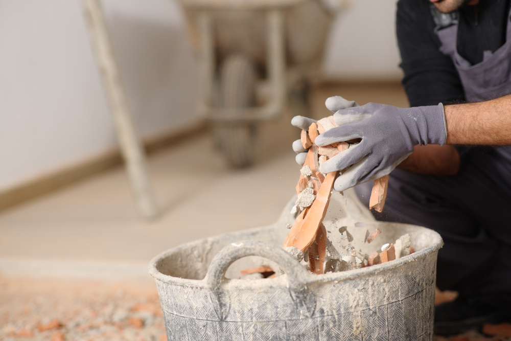 Close,Up,Of,A,Construction,Worker,Hands,Removing,Debris,To