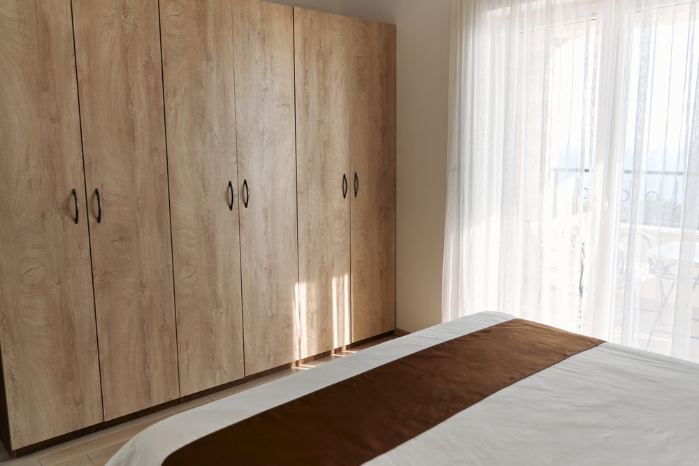 Sunlight,Gently,Illuminates,A,Cozy,Bedroom,Featuring,A,Wooden,Wardrobe